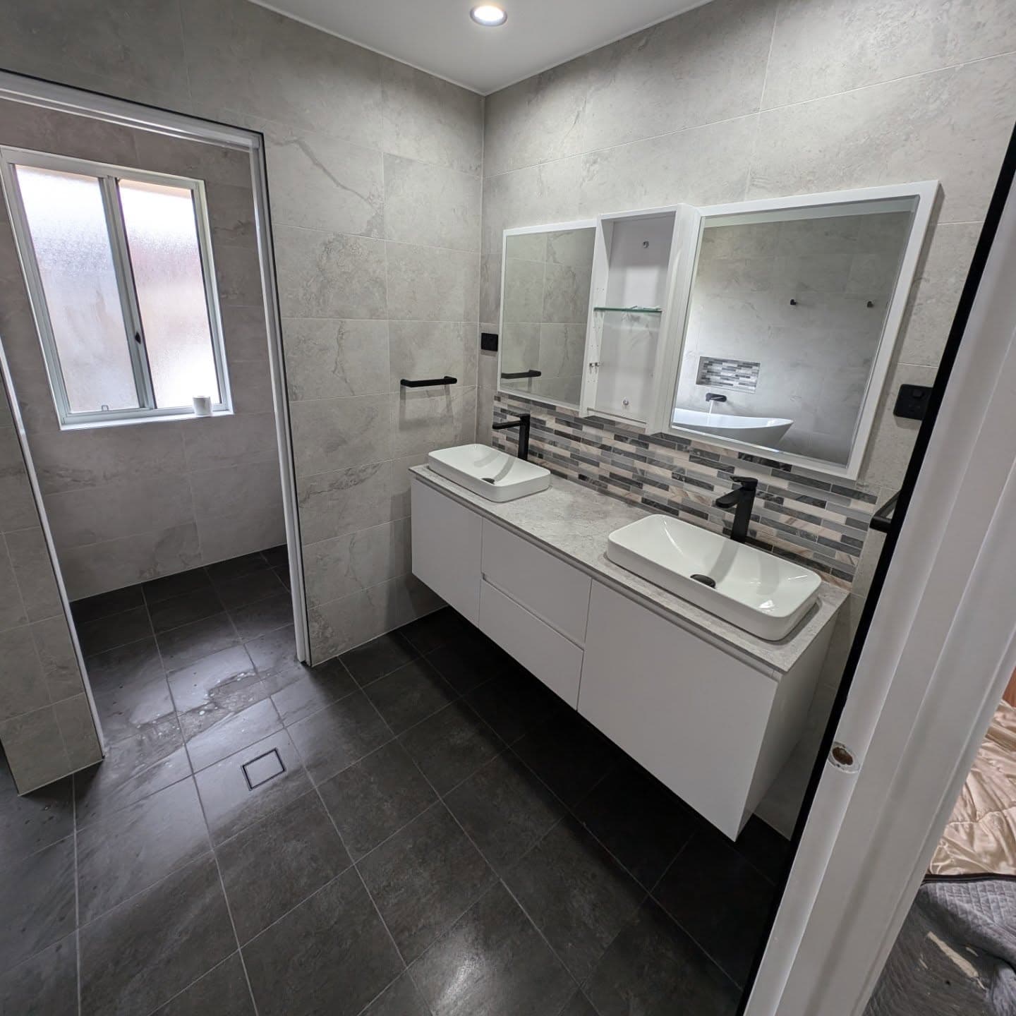 Family bathroom with double vanity, twin basins and mosaic feature tile